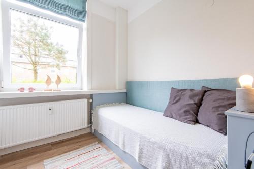 a small bedroom with a bed and a window at Steger-Hüs Wohnung 05 in Rantum