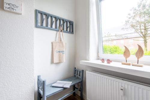 a blue bench sitting under a window next to a radiator at Steger-Hüs Wohnung 05 in Rantum