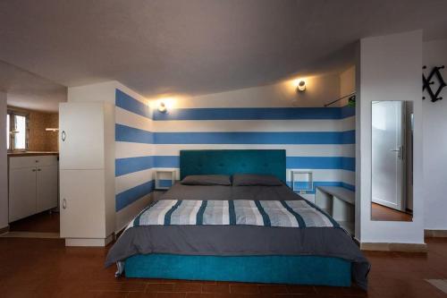 Schlafzimmer mit einem Bett mit blauen und weißen Streifen in der Unterkunft Sunset Manarola in Manarola