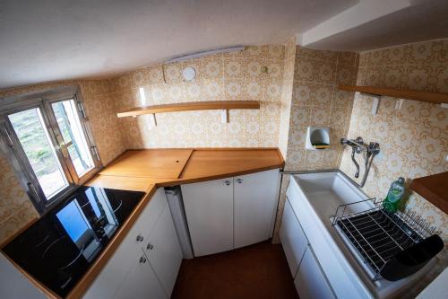 Una pequeña cocina con fregadero y estufa. en Sunset Manarola, en Manarola