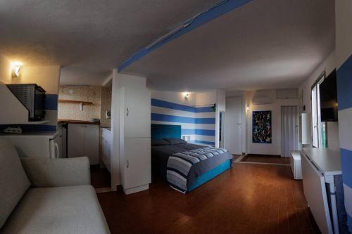 ein Schlafzimmer mit einem Bett und einer blau gestreiften Wand in der Unterkunft Sunset Manarola in Manarola