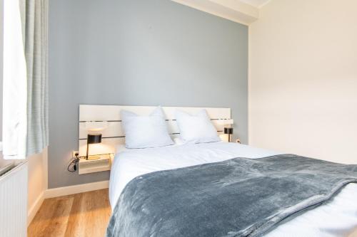 a bedroom with a large white bed with white pillows at Steger-Hüs Wohnung 10 in Rantum