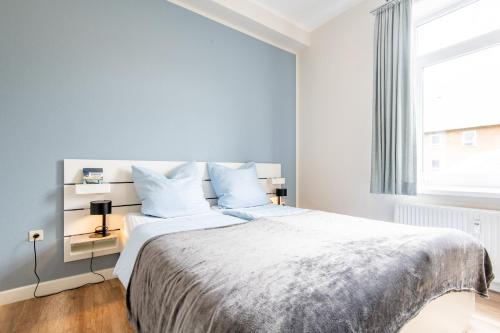 a bedroom with a large bed and a window at Steger-Hüs Wohnung 09 in Rantum