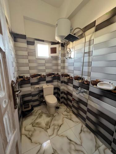a bathroom with a white toilet and a sink at People to People Siwa in Siwa