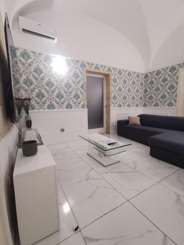a living room with a blue couch and a tile floor at Dimora San Biagio Suites&Apartment in Lecce