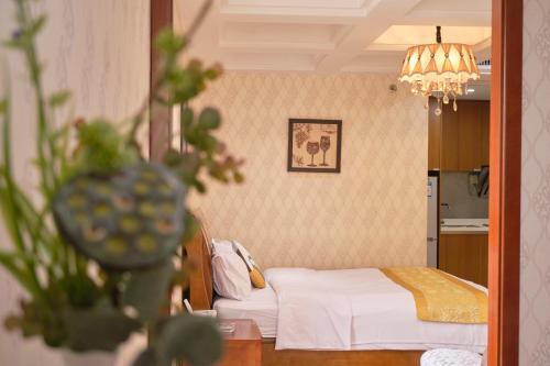 a bedroom with a bed and a chandelier at Guangzhou Uhome Service Apartment in Guangzhou