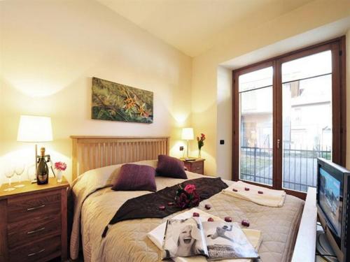 a bedroom with a bed and a tv and a window at Lenno Centrale in Lenno