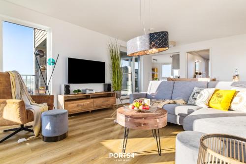a living room with a couch and a tv at Hafen Loft in Olpenitz