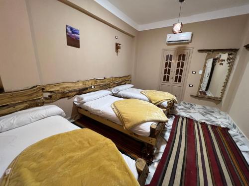 a bedroom with two beds and a rug at People to People Siwa in Siwa