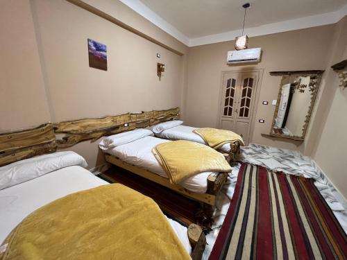 a room with two beds and a striped rug at People to People Siwa in Siwa