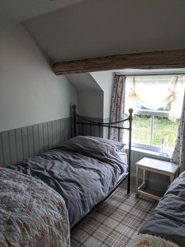 a bedroom with a bed and a window at Lilac Terrace Cottage in Danby
