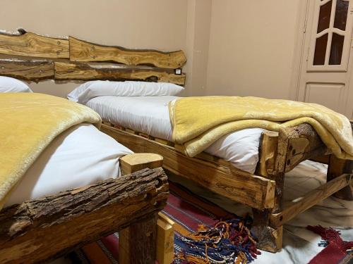 two beds in a room with wooden furniture at People to People Siwa in Siwa