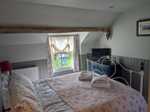 En eller flere senge i et værelse på Lilac Terrace Cottage