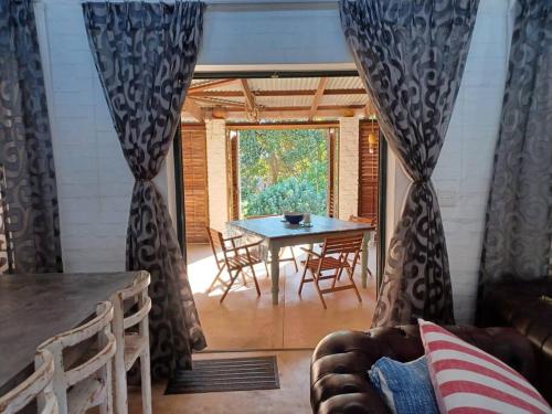a living room with a table and chairs and a window at Chillilabombwe in Pringle Bay