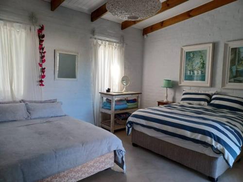 a bedroom with two beds and a chandelier at Chillilabombwe in Pringle Bay