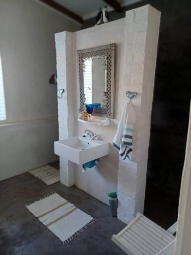 a bathroom with a sink and a mirror at Chillilabombwe in Pringle Bay