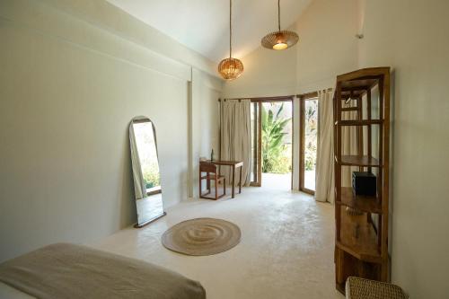 Cette chambre comprend un lit, une table et une porte. dans l'établissement SEACLUB Siargao, à General Luna