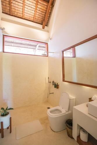 a bathroom with a toilet and a sink at SEACLUB Siargao in General Luna