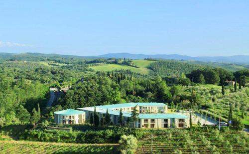 una vista aérea de una casa en una colina en ISA-Residence with swimming-pool in Barberino-Tavernelle, apartments with air conditioning and private outdoor area, en Tavarnelle in Val di Pesa
