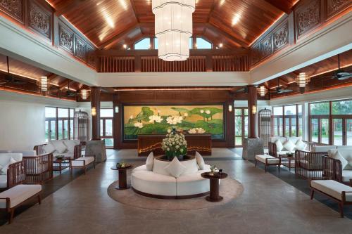 a lobby with a couch and chairs and a painting at Senna Wellness Retreat in Bắc Ninh