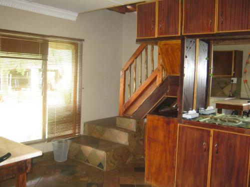 cocina con escalera de madera en una habitación en Emahlathini Guest Farm, en Piet Retief