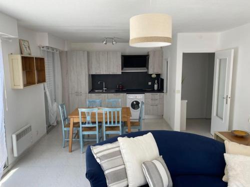 un salon avec un canapé bleu et une table dans l'établissement Menton Karma - Parking & Terrace, à Menton