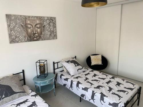 - une chambre avec un lit et une statue sur le mur dans l'établissement Menton Karma - Parking & Terrace, à Menton