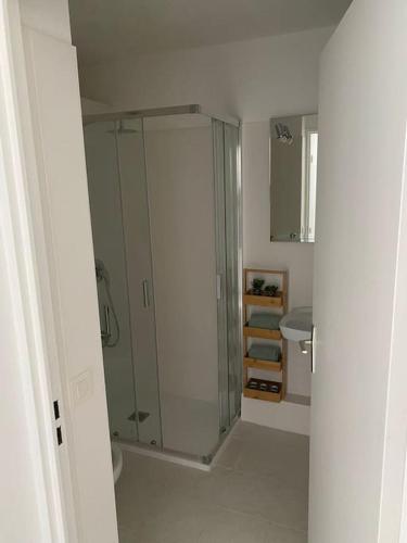 une salle de bain blanche avec une douche et un lavabo dans l'établissement Menton Karma - Parking & Terrace, à Menton