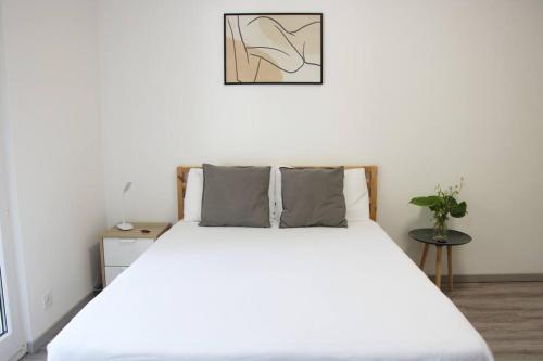 - une chambre avec un grand lit et des draps blancs dans l'établissement Lovely Studio with Free Parking!, à Lugano