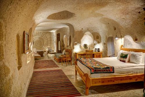 a bedroom with a bed in a stone room at Petra Inn Cappadocia in Uchisar