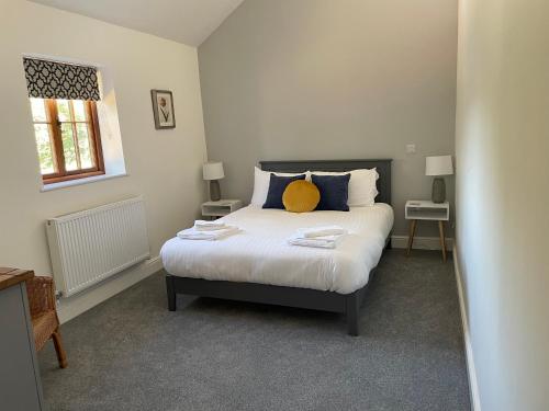 a bedroom with a bed with a yellow pillow on it at The Old Dairy in Chappel