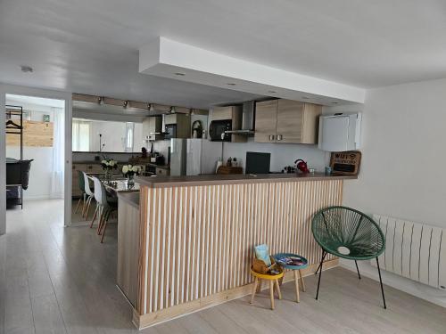 eine Küche mit einer Theke und Stühlen in einem Zimmer in der Unterkunft T2 calme et cozy, proche transports in Aulnay-sous-Bois