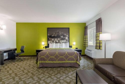 a hotel room with a bed and a couch at Super 8 by Wyndham De Soto in De Soto