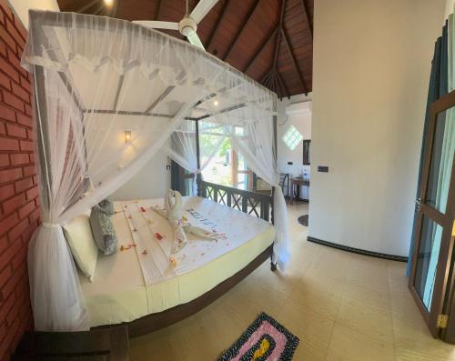a bedroom with a bed with a canopy at Dosemo Cabana in Induruwa