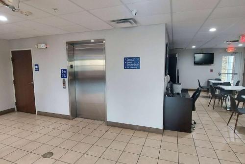an office lobby with a door and a table with chairs at Microtel Inn & Suites by Wyndham Hoover/Birmingham in Hoover