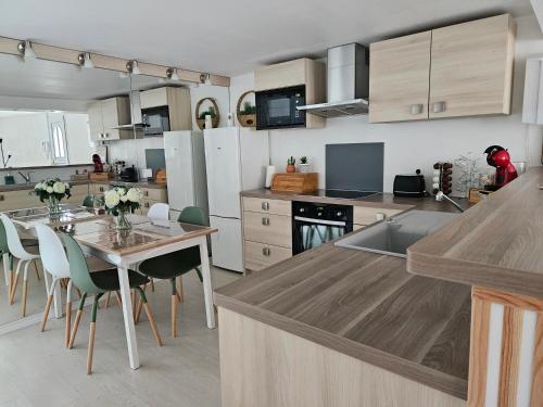 eine Küche mit einem Tisch und Stühlen sowie eine Küche mit einer Theke in der Unterkunft T2 calme et cozy, proche transports in Aulnay-sous-Bois