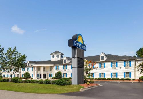 a street sign in front of a large building at Days Inn by Wyndham Shallotte in Shallotte