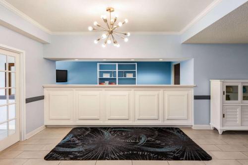 a living room with a chandelier and a white cabinet at Days Inn by Wyndham Shallotte in Shallotte