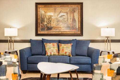 a blue couch in a living room with a painting at Days Inn by Wyndham Shallotte in Shallotte