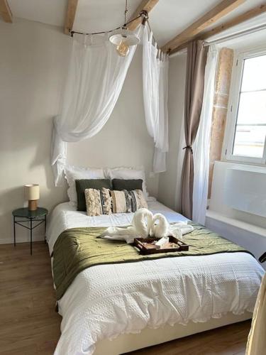 a bedroom with a large bed with a stuffed animal on it at LE NOUMÉA, T2, Hyper-centre, Square de la Paix in Mâcon