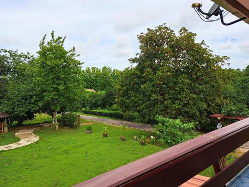 a balcony with a view of a yard with trees at AURA Park Resort in Ban Thung Sam Sao