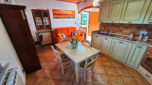 a kitchen with a table and chairs in a kitchen at Spicchio di Luna - Casa Vacanze in Albiano