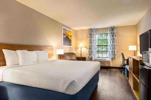 a hotel room with a bed and a television at Days Inn by Wyndham Shallotte in Shallotte
