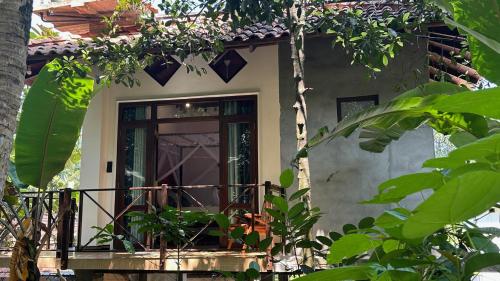 une porte d'entrée d'une maison avec une terrasse couverte dans l'établissement Dosemo Cabana, à Induruwa