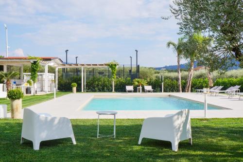 a pool with two chairs and a table in the grass at Biancolivo Country House in Altavilla Silentina