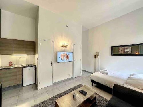 Una sala de estar con una cama y una cocina. en Cosy appart Lyon 6/métro foch-bossuet 1, en Lyon