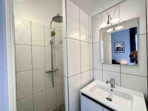 uma casa de banho branca com um lavatório e um espelho em Cosy appart Lyon 6/métro foch-bossuet 1 em Lyon