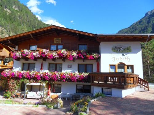 a hotel with flowers on the side of it at Gästehaus Judith in Längenfeld