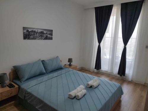 1 dormitorio con 1 cama con 2 toallas en Skopje Sky City 19th Floor Twin Apartments with Indoor Pool & Spa & Fitness Including in Price en Skopie