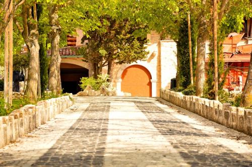 a cobblestone road with an archway and a bridge at Hotel La Valle dell'Aquila in LʼAquila